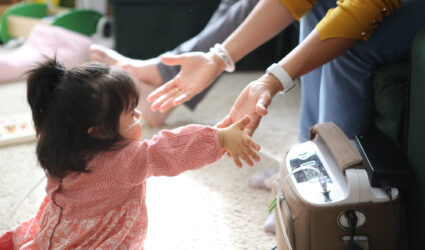 Eltern strecken ihre Hände nach ihrer kleinen Tochter aus.